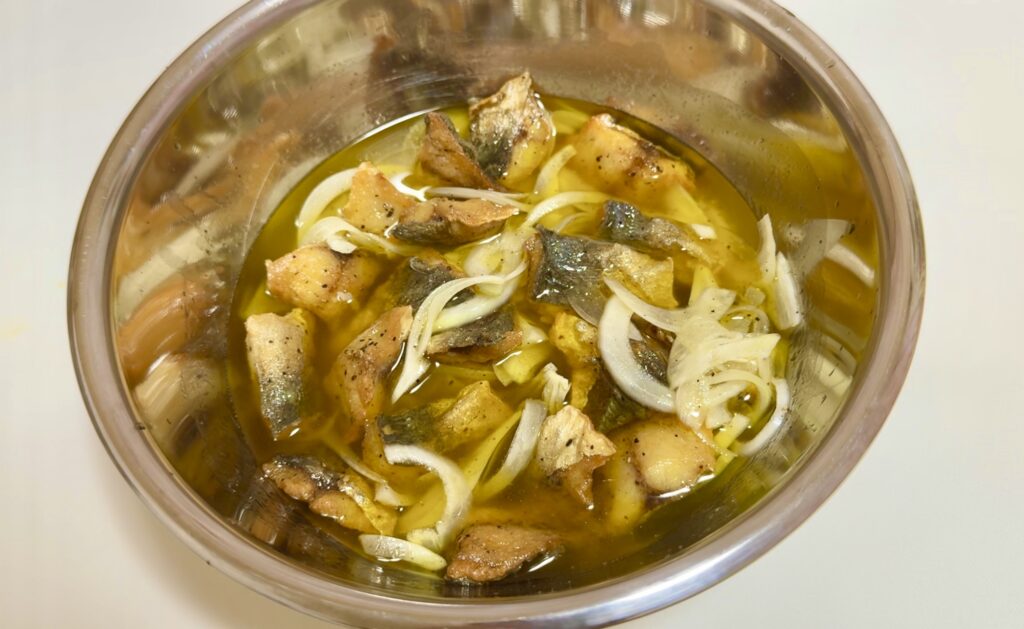 揚げた鯵をマリネ液に漬けこむ