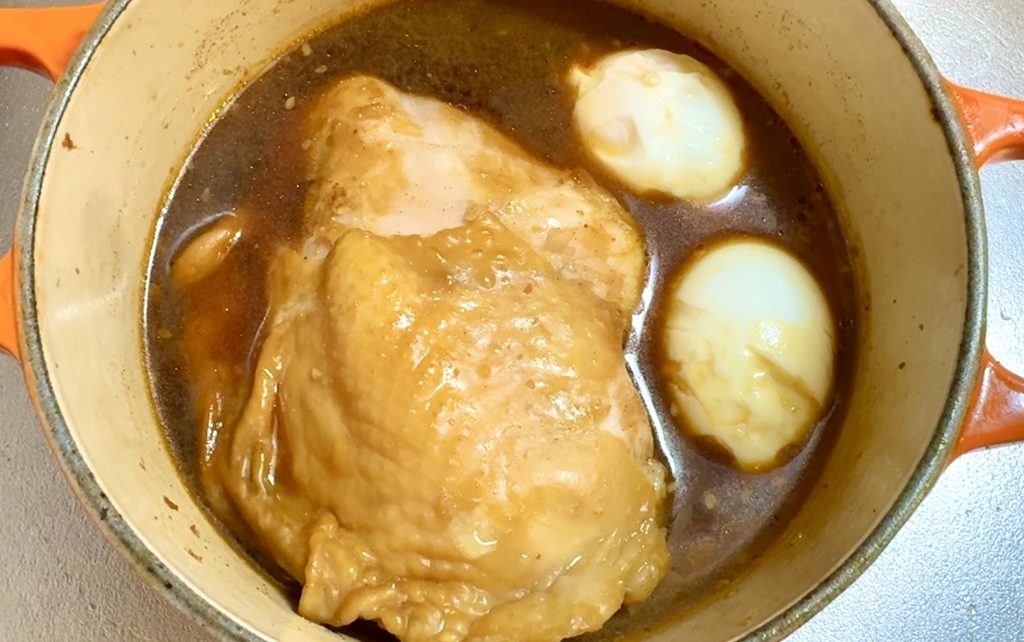 鶏チャーシューの煮汁にゆで卵を加えて味付き卵を作る様子