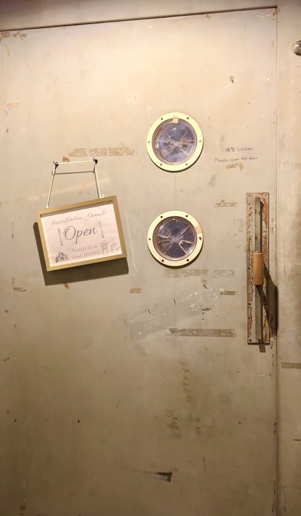 燻製キッチン大井町の丸い小窓が2つ並ぶ入口の扉