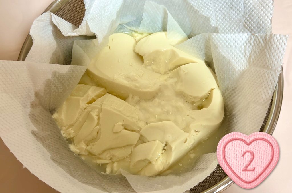 キッチンペーパーを敷いたザルで豆乳グルトを水切りする様子